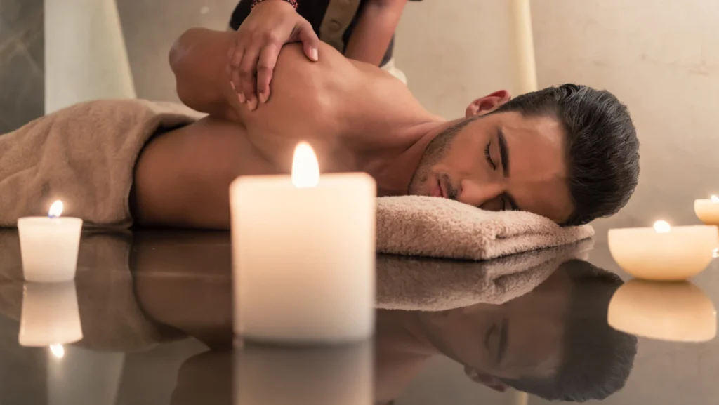 Young muscular man enjoying the healing benefits of traditional Thai massage at luxury spa and wellness center