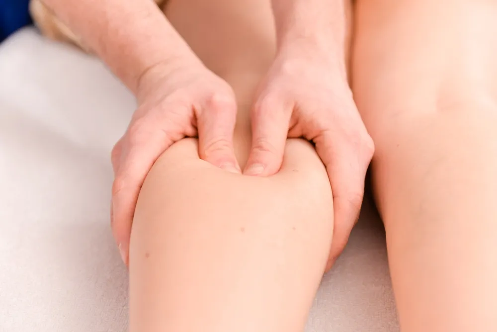 Therapist performing deep tissue leg massage