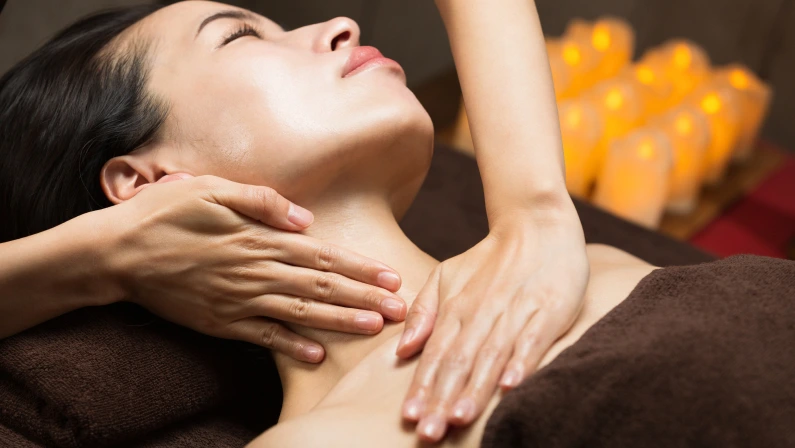 The woman has her neck massaged.