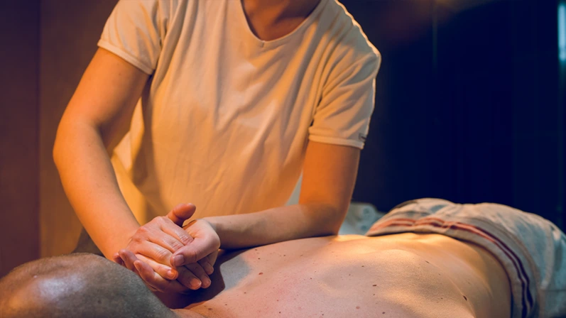 Young woman female massage therapist giving massaging relax sport to young athlete at spa studio arm hand