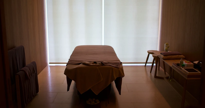 Room for body massage Bedding is empty. Natural sunlight shines from the opposite. For professional massage therapists and clients to relax and relieve muscle strain.