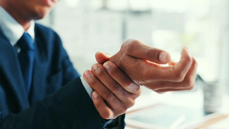 Hurt, businessman or hands in office with wrist pain, carpal tunnel syndrome or arthritis from fatigue. Tired, person or burnout in workplace from joint inflammation, fibromyalgia discomfort or issue